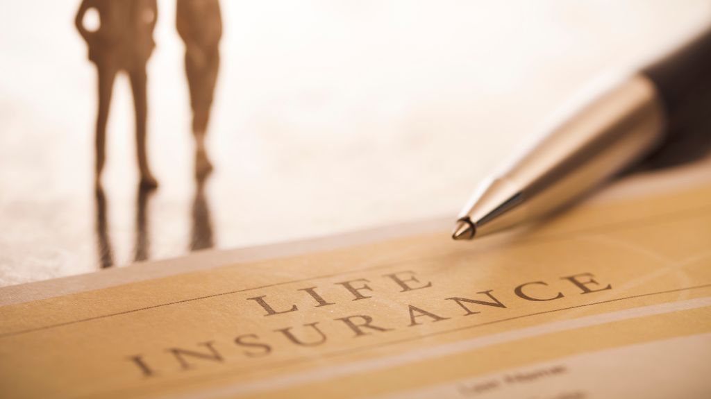 Close Up of Life Insurance Policy Folder and Pen with Man and Woman in the Background