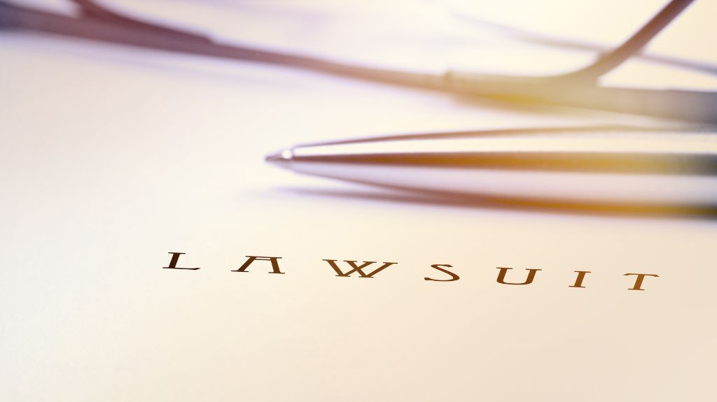 Black Lawsuit Text on a Document with a Pen in the Background